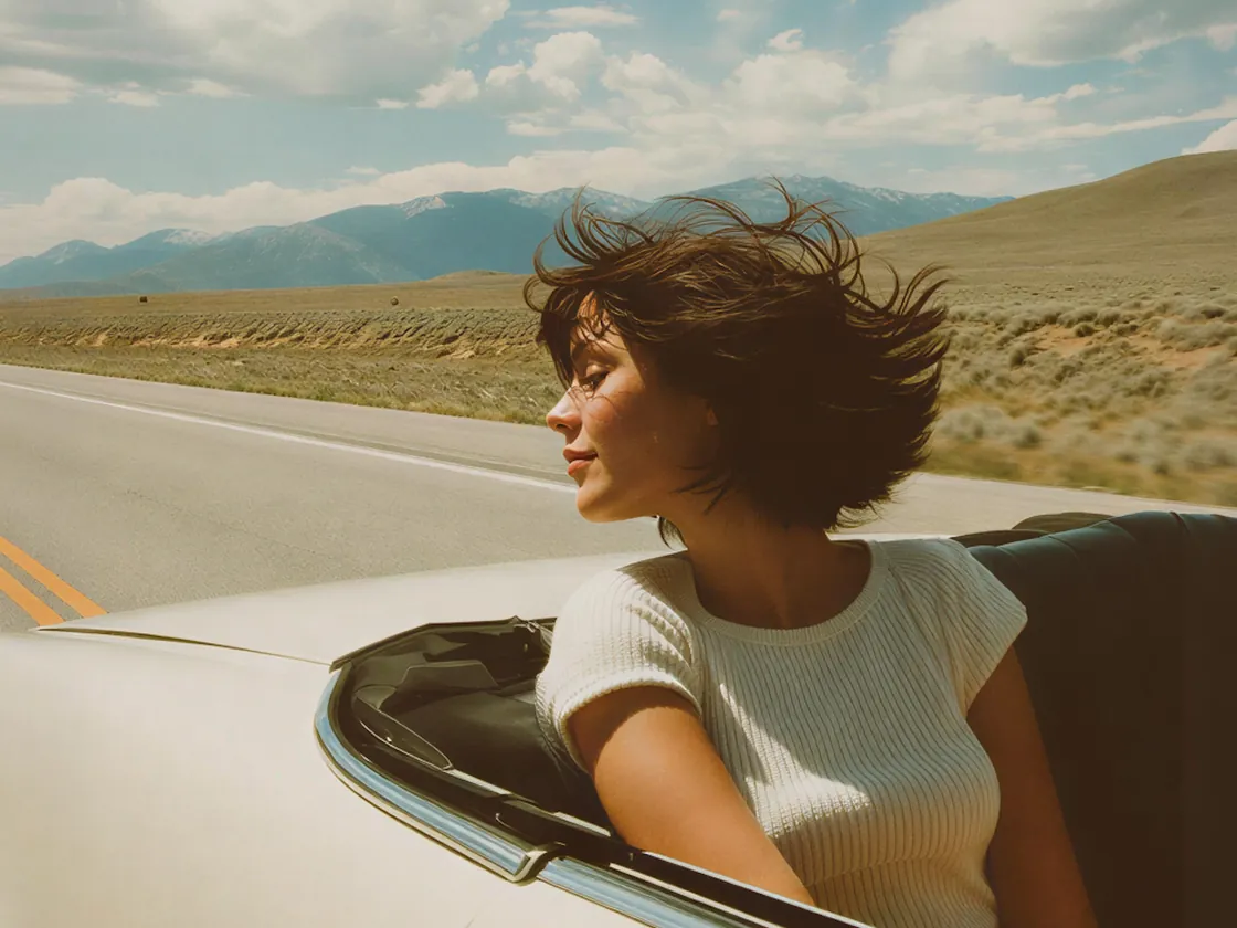 Woman driving a white convertible on an open desert road