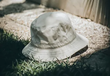 Beige bucket hat on stone and grass